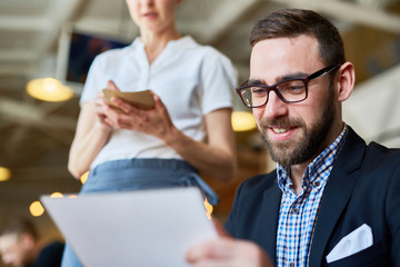 Businessman choosing food from menu and waitress taking his order