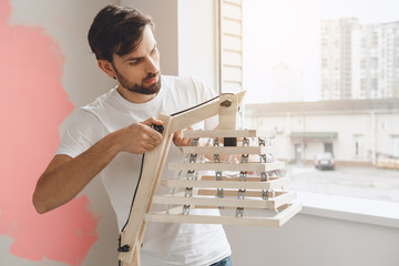 Young man does apartment repairment himself indoors