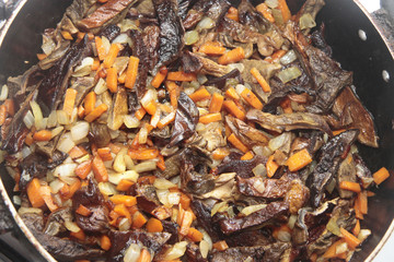 Mushrooms fried on the pan with carrot and onion