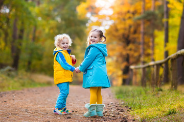 Kids play in autumn park. Children in fall.