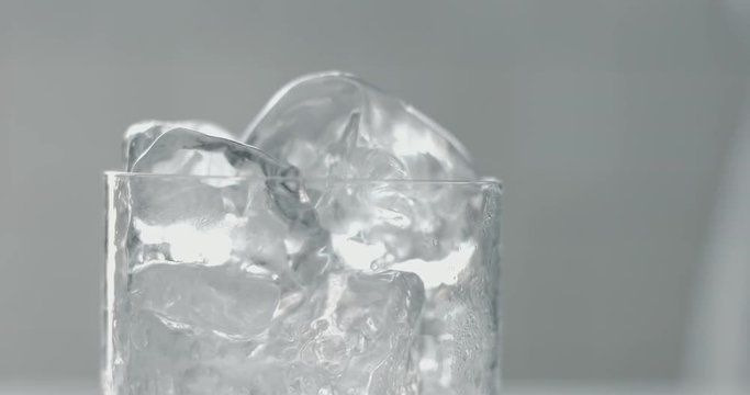 Barista turns on cubes of ice in glass
