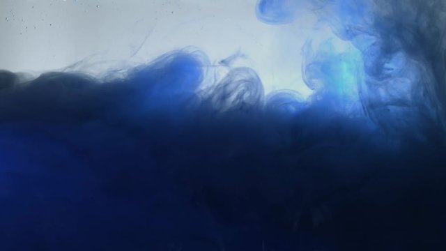 Blue color paint pouring in water. Acrylic colors and ink in water. Abstract frame background. Colors and ink in water