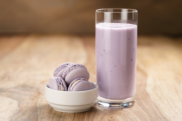 violet macarons in white bowl with blueberry yogurt on wooden table