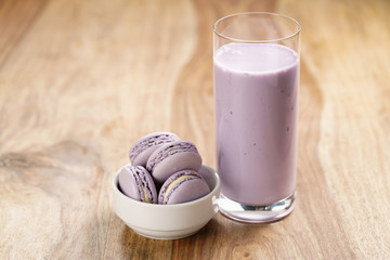 violet macarons in white bowl with blueberry yogurt on wooden table