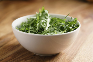 fresh green rocket salad arugula leaves in white bowl
