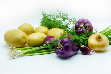 Assortment of fresh raw vegetables on white background. Selection includes potato, green onion, pepper, garlic and dill