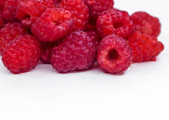 Juicy raspberry raspberries scattered on white