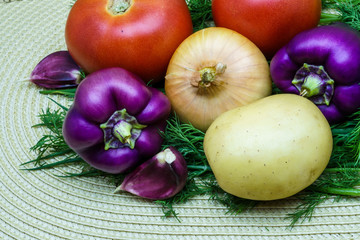 Assortment of fresh raw vegetables on a napkin. Selection includes potato, tomato, green onion, pepper, garlic and dill