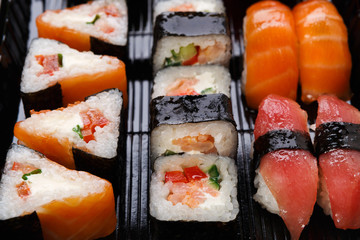 Set of sushi maki and rolls closeup in delivery box