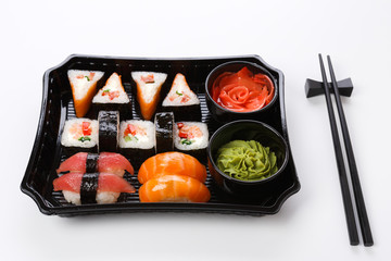 Set of sushi maki and rolls closeup in delivery box isolated at white