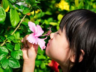 Obraz na płótnie Canvas Asian Girl Smelling Flowers