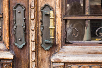 Closeup of old wood exterior door with brass handles 