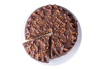 isolated chocolate layered cake with nougat and sponge cake in the cut on the plate, top view
