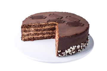 isolated chocolate layered cake with nougat and sponge cake in the cut on the plate
