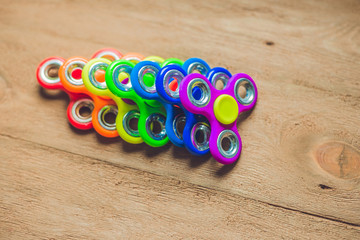 Colored fidget spinners stress relieving toy on wooden background