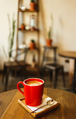 Red cup of coffee in a cafe on table. Place for rest