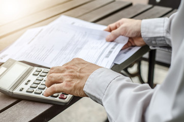 Man using calculator and thinking about cost  with paying bills