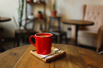 Red cup of coffee in a cafe on table. Place for rest