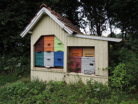 Bienenst&ouml;cke in einem bunten Holzhaus