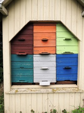 Bienenst&ouml;cke in einem bunten Holzhaus
