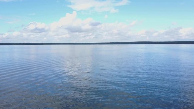 Vast blue lake background with moderate waves looking straight down. Aerial view of blue river