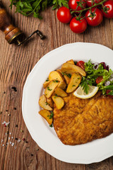 Chicken schnitzel, served with roasted potatoes and salad.
