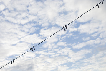 Obraz premium Blue clothesline over cloudy sky