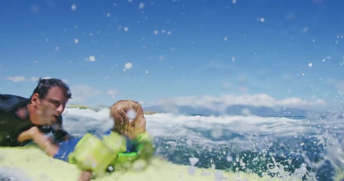 Father teaching son to surf tandem surfing