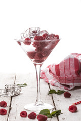 Summer cold drink with raspberry, mint and ice in glass on white background