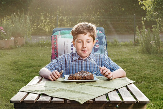 Happy Boy Eating A Steak In The Garden