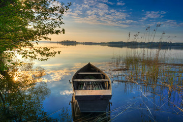 Naklejka premium Rowing boat floating over the Lake Selment Wielki waters. Masuria, Poland.