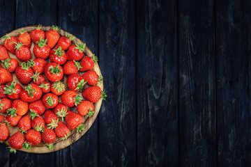 Strawberries on a plate on a wooden table