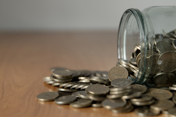 Overturned glass jar full of coins, money box