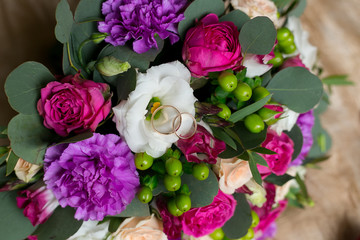 Fototapeta na wymiar wedding bouquet of peonies with wedding rings