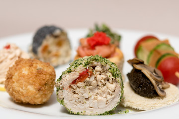 Different types of canapes, placed on white plates, finger food, light brown background