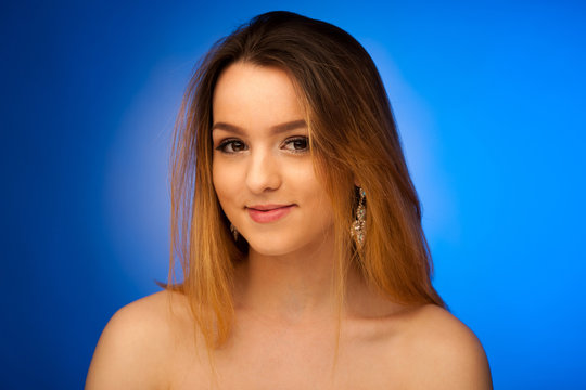 Beauty portrait of a cute teenage girl over blue background