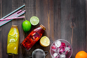 Bottle of fresh lemonade, fruits and ice cubes on wooden background top view copyspace