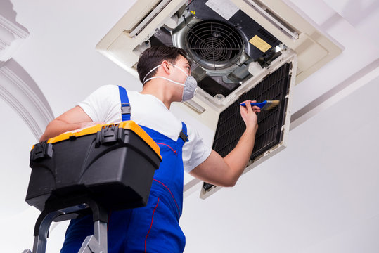 Worker Repairing Ceiling Air Conditioning Unit