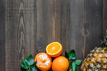 Citrus concept. Oranges, pineapple and mandarins on wooden table background top view copyspace
