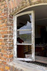 Window with broken glass panes in brick wall