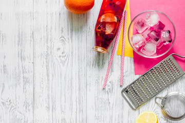 Making lemonade. Cookware, fruits, bottle of lemonade and ice cubes on wooden table background top view copyspace