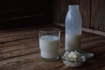 Sour-dairy drink or yoghurt in bottle that come from the kefir grains and milk on wooden background. Photographed with natural light