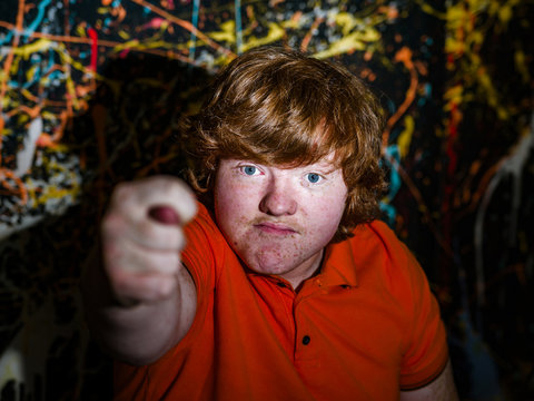 Red-haired funny boy showing fig sign