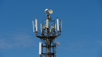 Fototapeta na wymiar telecommunication cellular tower against blue sky