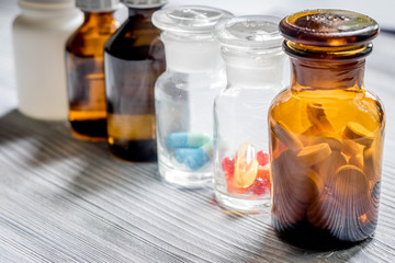 Vitamins and supplements. Pills and pill bottle on grey wooden table background copyspace