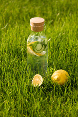 A glass decanter with a summer refreshing lemonade made of lemons and cucumber with mint added on a...