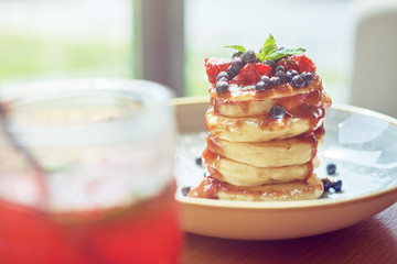 food background of stacked pancakes with sugar souse in sunny cafe at morning