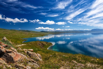 Fototapeta na wymiar Mountain Song Kol lake. Beautiful clouds reflected in water. Kyrgyzstan.