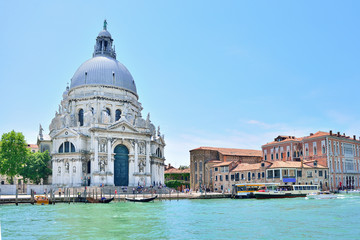 Fototapeta na wymiar Beautiful view on Canal Grande with historic Basilica di Santa Maria della Salute in the background on a sunny day in Venice, Italy
