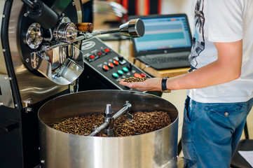 The expert tests the coffee roasting machine. Unique quality and aroma come with an excellent taste, which is distilled from coffee beans, can create a business and have a huge market value.